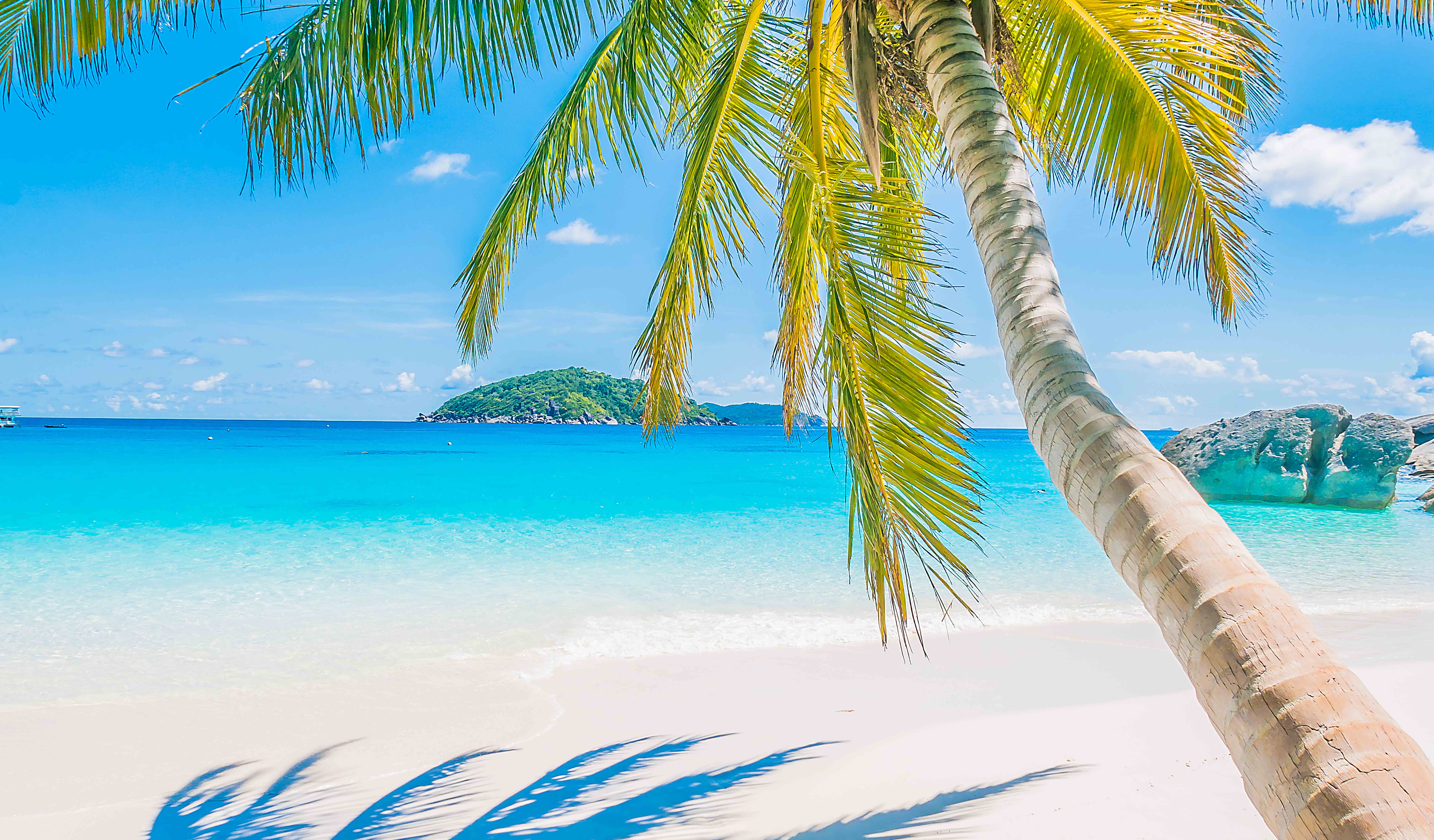 Beautiful young fashion woman with striped dress and hat in Capri Island with Faraglioni sea stack and blue crystalline water on the background, Capri, Italy